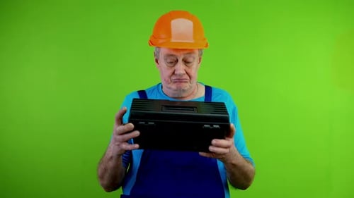 Arbeiter im Overall schauen sich die Werkzeugkiste an und rühmen sich ihrer Qualität