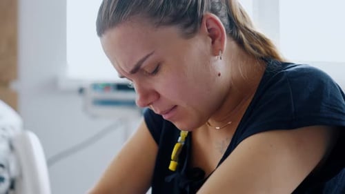 Kaukasische Frau, die an Kontraktionen leidet. Die werdende Mutter hat Schmerzen und atmet langsam.