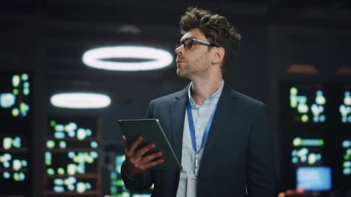Serious IT Specialist Working Tablet in Data Center Closeup Man Looking Asides