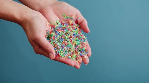 Hands Holding and Releasing Colorful Confetti