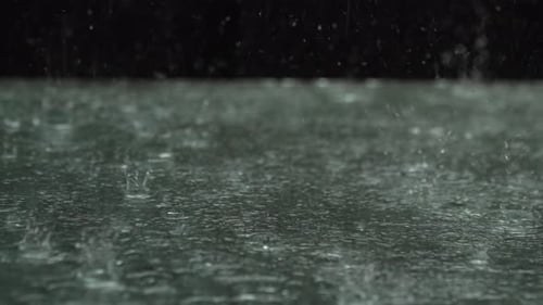 Rain Drops Splashing on a Reflective Surface