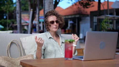 Woman Working Remotely at Tropical Cafe