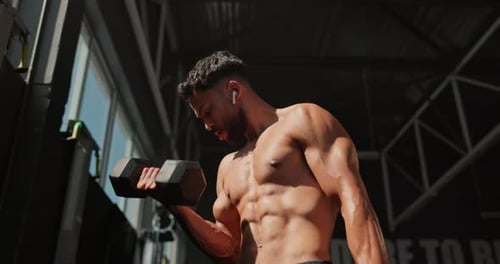 Music, dumbbell and man exercise for muscle, wellness and body health in gym