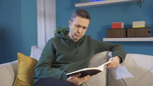 Man Relaxing on Couch Reading a Book