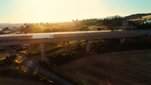 Aerial Shot of a White Truck with Cargo Load Moving on the Massive Bridge with Traffic on it in the