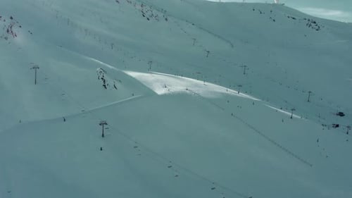 Beautiful snowy ski slopes and chairlifts on ski resort mountain, aerial view