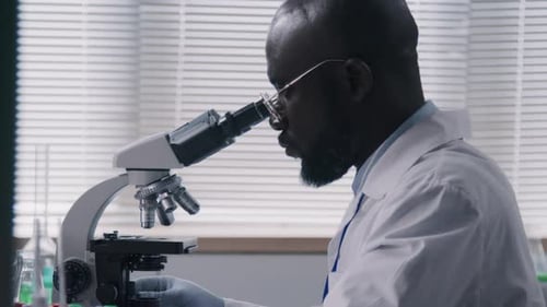 Chemist Examining Sample in Microscope