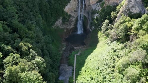 Aerial View Of A Beautiful Waterfall Surrounded By Forest