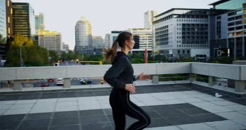 An attractive young woman checking the time while out jogging in the city
