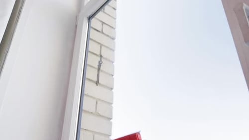 Hand Uses Window Cleaning Tool on Glass