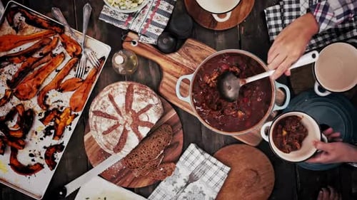 Overhead of Family Serving Beef Stew on Wooden Table