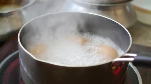 Eier in heißem Wasser in einer Kochpfanne kochen