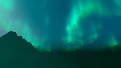 Aurores boréales au-dessus des montagnes enneigées la nuit d'hiver