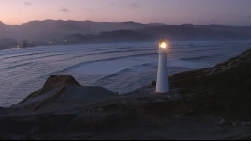 Lighthouse overlooks the bay at dusk.