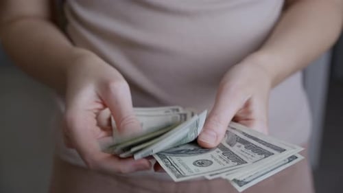 Close-up shot, men's hands are counting one hundred dollar banknotes.