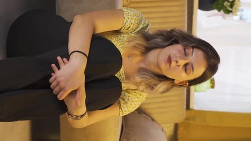 Young Woman Sitting on Couch Relaxing Indoors