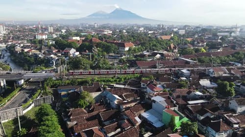 Drones follow trains that run in urban Yogyakarta, and show beautiful and bright views of Mount Mera