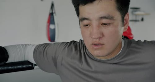 Slow Motion of Exhausted Boxer Resting in Ring Corner Breathing During Break in Competition