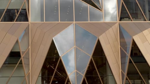 Survol d'un bâtiment moderne complexe de forme géométrique avec fenêtres en miroir Vidéothèque