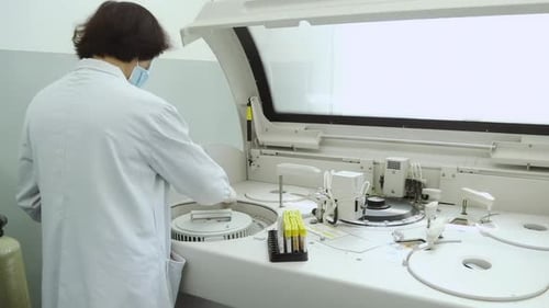 Lab Technician Analyzing Samples with Automated Equipment