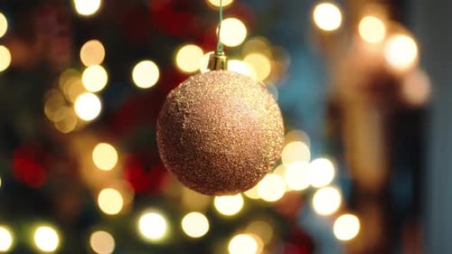 Gold Glittery Ornament Hanging on Christmas Tree