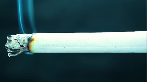 slow burning cigarette without anyone to puffing inhaling in the smoke releasing clouds of fog pollu