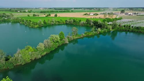 Drone shot over lakes in the middle of fields in sunny day