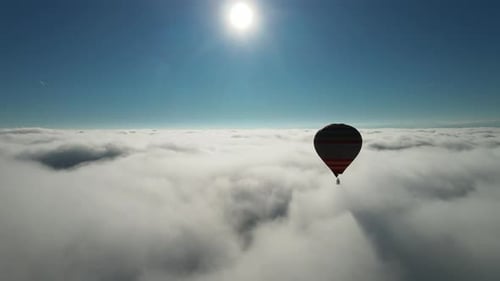 Hot Air Balloon Drifting Among Clouds on Sunny Day