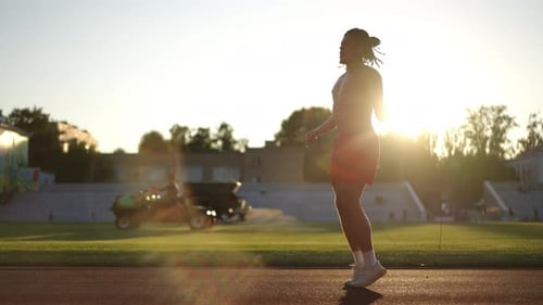 Slow Motion Shooting Against the Sun Young Athlete with Dreadlocks in Red Athletic Shorts Jumping