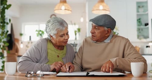 Senior Couple Reviewing Documents at Kitchen Table