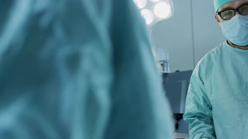 Close-up Shot in the Operating Room, Assistant Hands out Instruments to Surgeons During Operation.