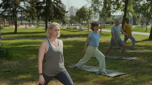 Adults Practice Yoga Outdoors in Sunny Park