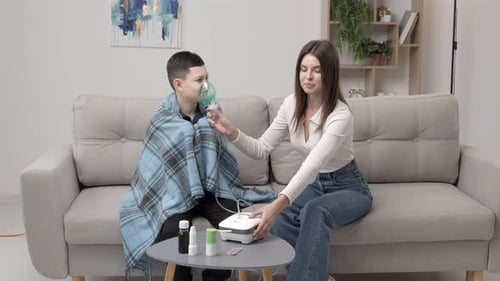 Woman Assists Child Using Inhaler Machine at Home