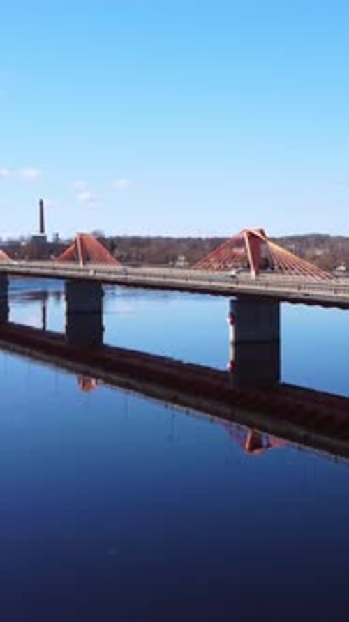Vertikale Weitwinkelaufnahme einer Schrägseilbrücke über einen Fluss am Stadtrand. Südlich
