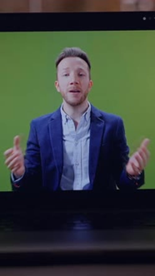 A Professional Speaker Engaging with the Audience While Presenting in Front of a Green Screen