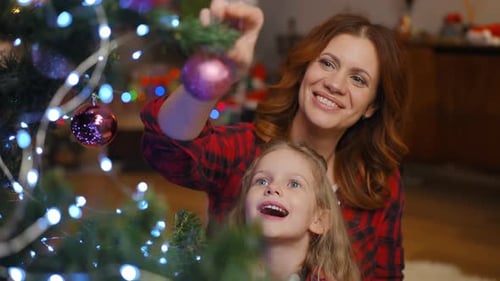 Woman and Child Decorating Christmas Tree Together