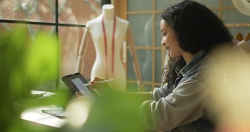 Female Designer Uses Tablet in Fashion Studio