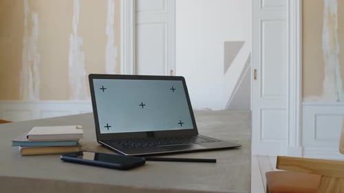Laptop with Empty Screen, Smartphone and Notebooks on Table in Minimalist Lounge