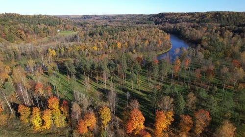 Autumn colors over tranquil river valley in a forested landscape