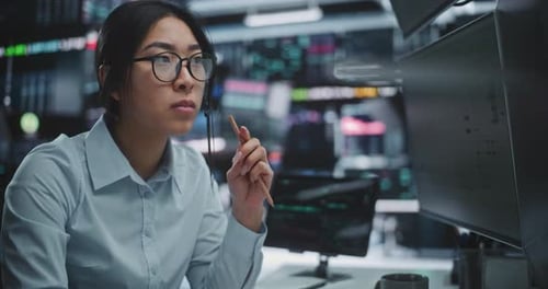 Focused Woman Analyst Working with Financial Data on Computer