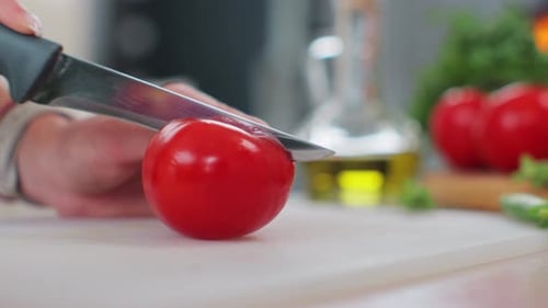 Close Up of Woman Hands Cutting a Fresh Tomato with Knife on Board Salad Preparation