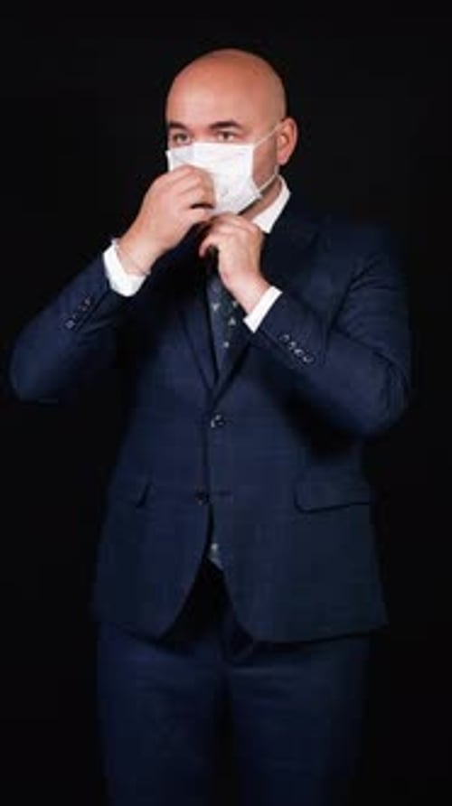Businessman wearing protective face mask on black background