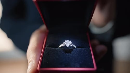 Handzeigender Ehering in Nahaufnahme der Wohnung: Freund schlägt Heiratsantrag
