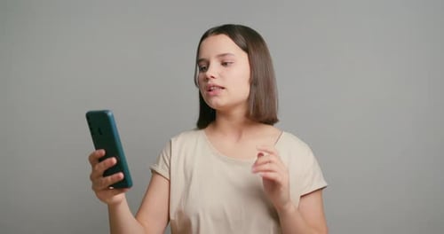 Teenager Waving During Video Chat on Smartphone