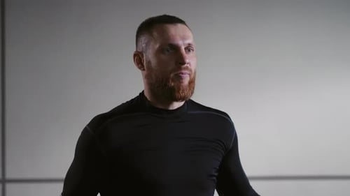 Athletic Man with Beard Looks at Camera