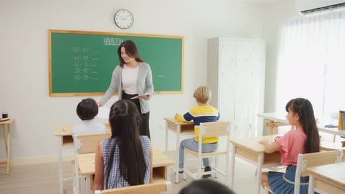 Group of student learn with teacher in classroom at elementary school.