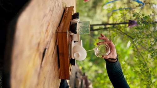 vertical video close-up The hands of professional tea master who pours fresh natural green tea