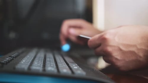 a cinematic picture of male hands and fingers filling out payment details. the programmer works from