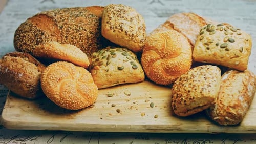 Variety of Freshly Baked Bread and Rolls on Board