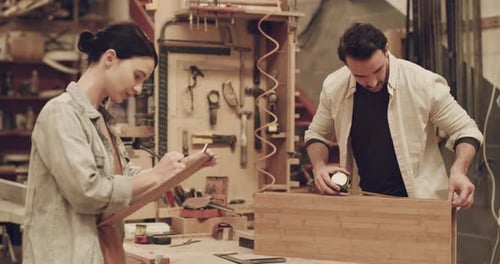 4k video footage of two young carpenters working together inside a carpentry workshop